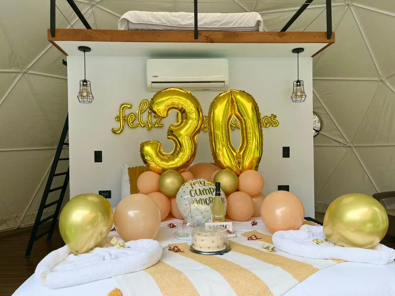 Decoración de cumpleaños en tonos dorados dentro de un domo de Macas Moon